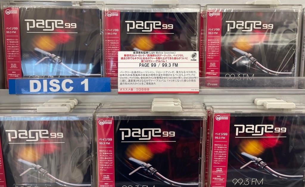 Display of “Page 99 – 99.3 FM” CDs featured in a Japanese record store, with Japanese obi strips and promotional card highlighting the band’s West Coast AOR sound.